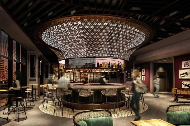 Un bar élégant avec un comptoir central et des tabourets.