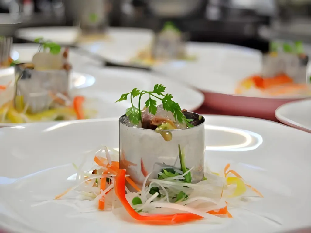 Présentation raffinée d'un plat gastronomique sur une table dressée.