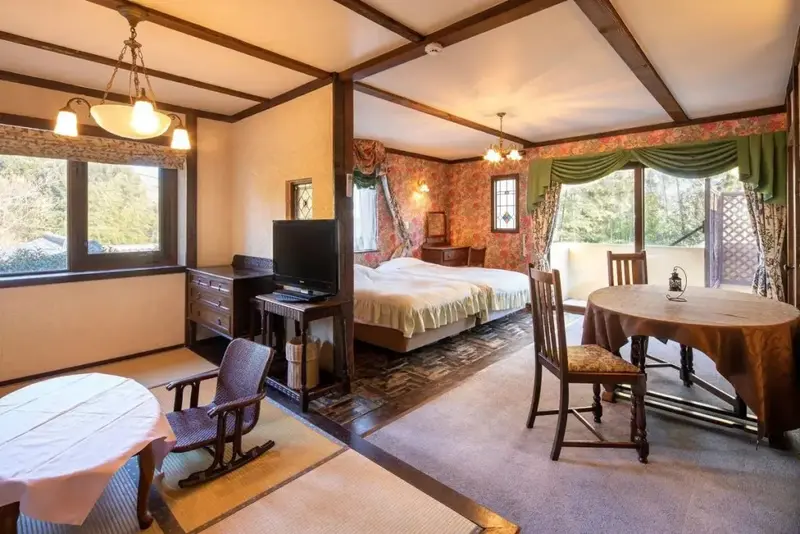 Une chambre lumineuse avec un lit double et un coin repas.