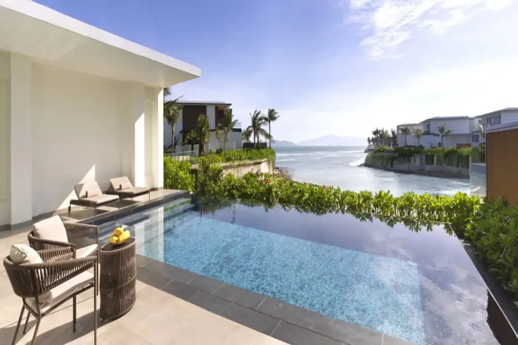 Une piscine à débordement offre une vue sur la mer et les bâtiments environnants.