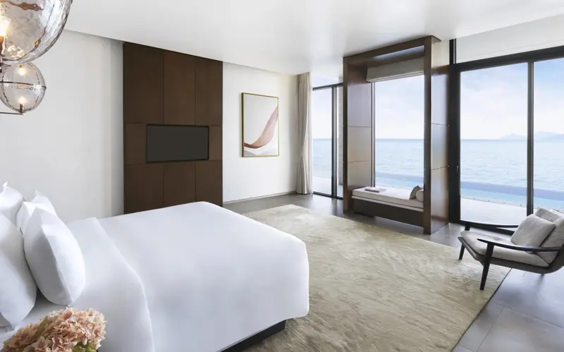 Une chambre lumineuse avec un grand lit et une vue sur la mer.