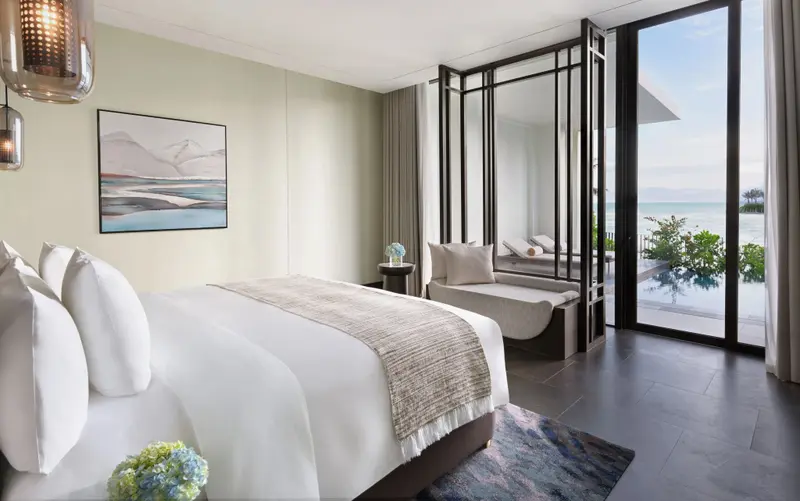 Une chambre lumineuse avec un grand lit et une vue sur la mer.