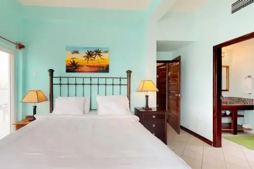 Une chambre lumineuse avec un grand lit et une décoration tropicale.