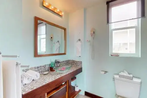 Une salle de bain lumineuse avec lavabo et douche.