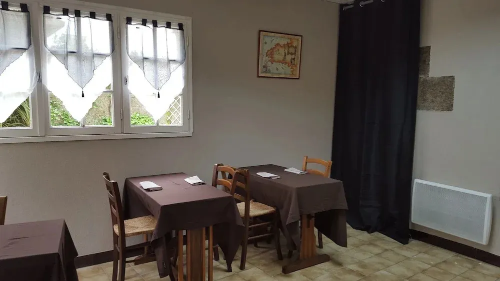 Une salle lumineuse avec des tables dressées près de fenêtres.