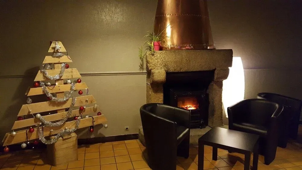 Un salon chaleureux avec un sapin de Noël artisanal près d'une cheminée allumée.