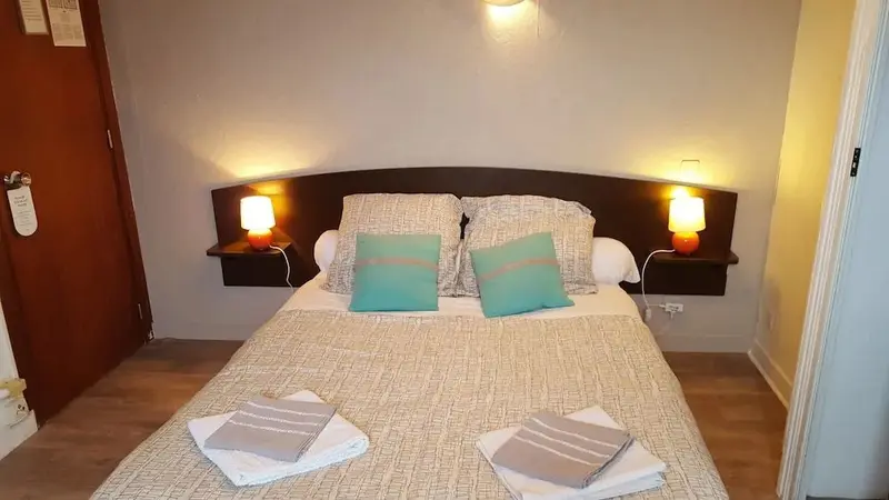 Une chambre à coucher avec un grand lit recouvert d'une couette et de coussins.