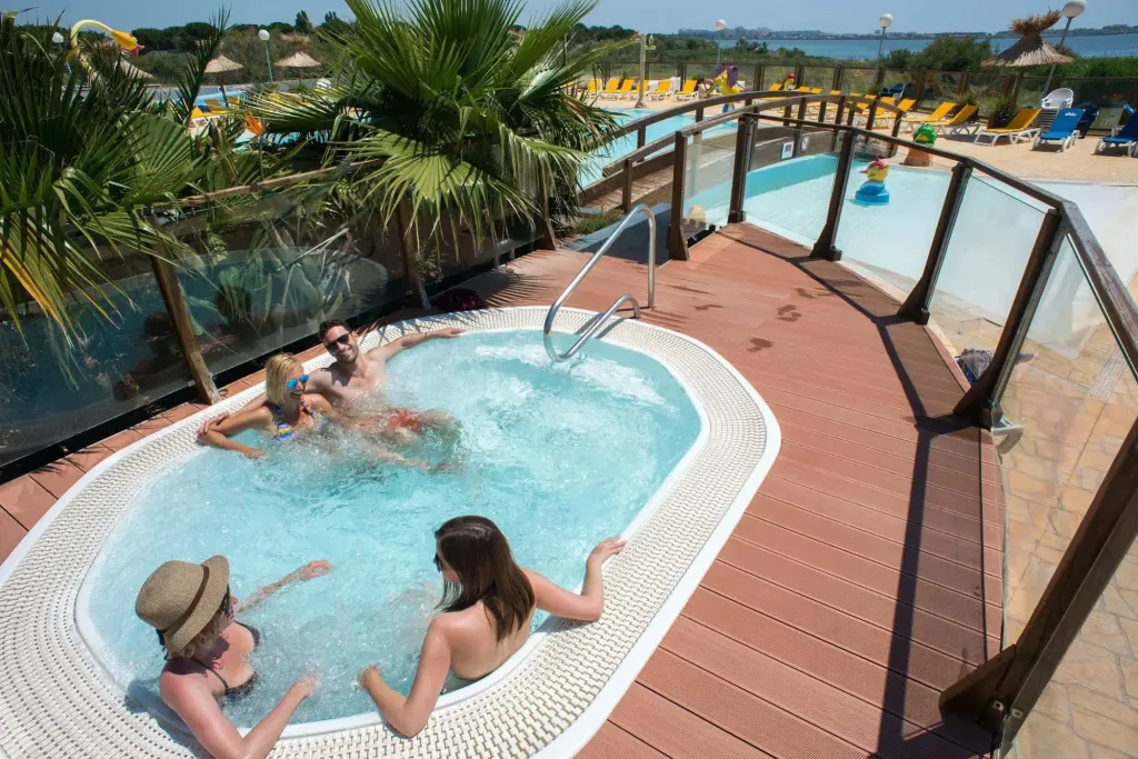 Des personnes se détendent dans un jacuzzi extérieur ensoleillé.