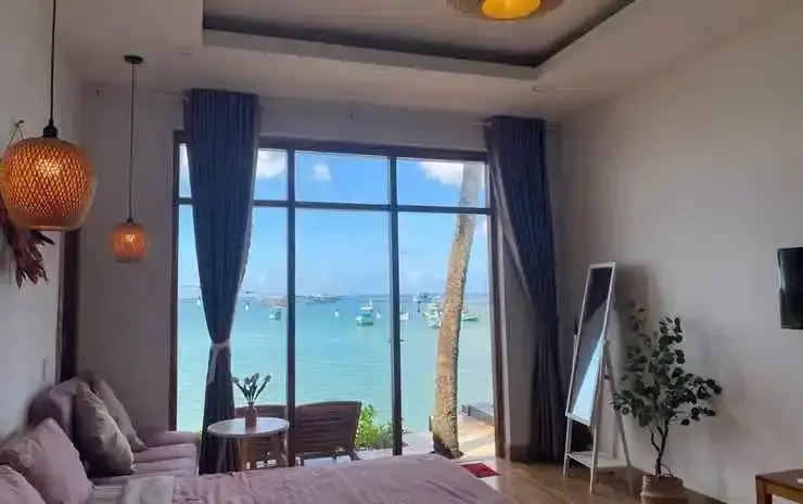 Une chambre lumineuse donne sur une vue maritime avec des bateaux amarrés.
