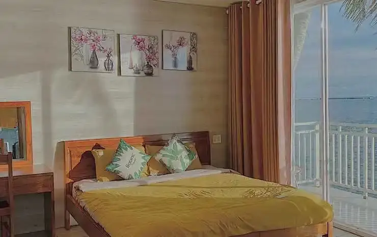 Une chambre lumineuse avec un grand lit et un accès à un balcon.