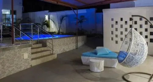 Une piscine illuminée avec des marches et un espace de détente extérieur.