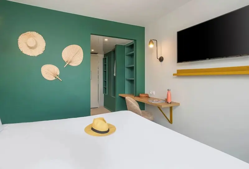 Une chambre lumineuse avec un bureau et des décorations murales.