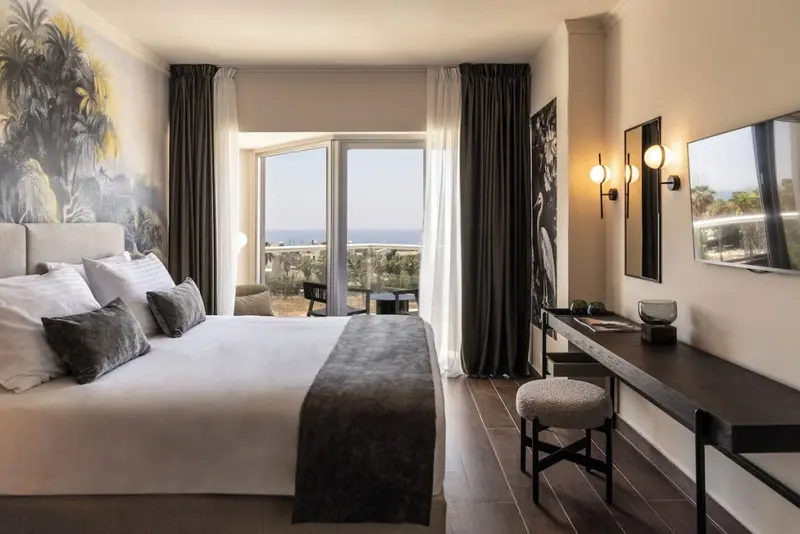 Une chambre lumineuse avec un grand lit et une vue sur la mer.