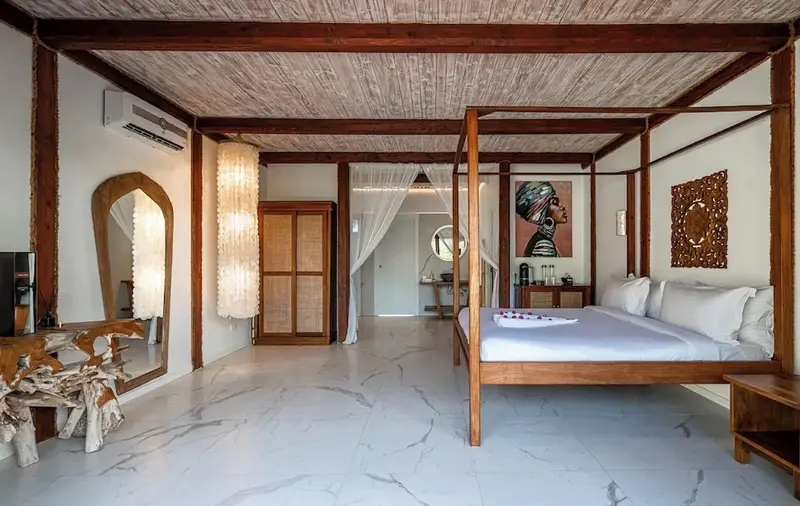 Une chambre spacieuse avec un lit à baldaquin et un décor mural coloré.