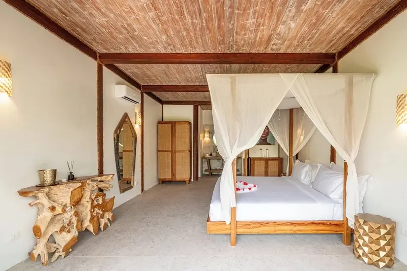 Une chambre lumineuse avec un lit à baldaquin et une décoration en bois.