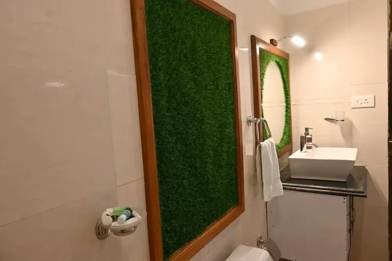 Une salle de bain lumineuse avec un mur recouvert d'un gazon artificiel.