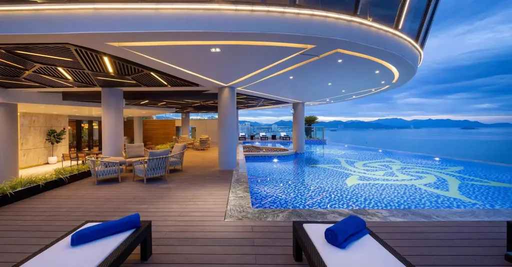 Terrasse avec piscine à débordement et mobilier de détente.