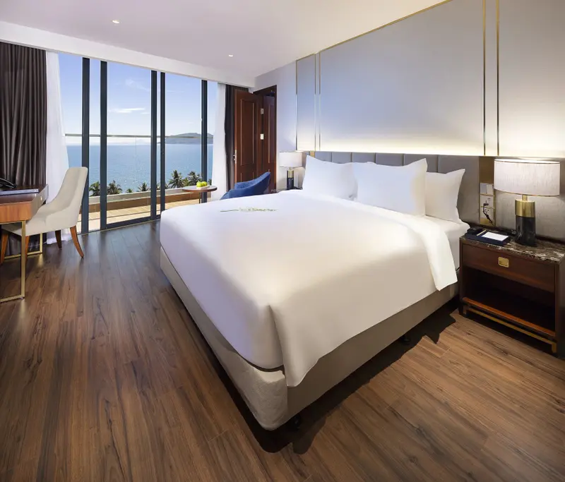 Une chambre lumineuse avec un grand lit et une vue sur la mer.