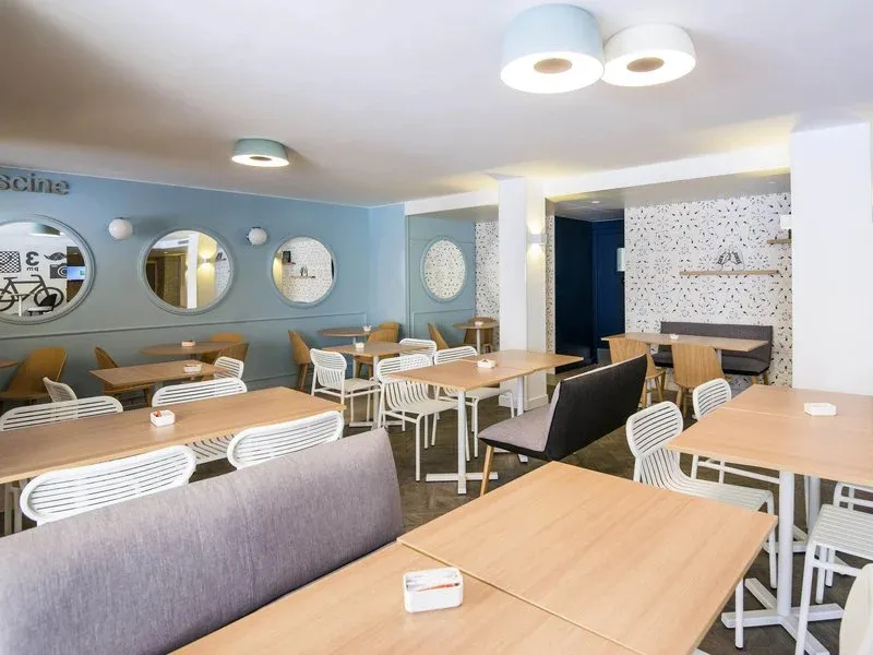 Une salle lumineuse avec des tables et des chaises pour les repas.