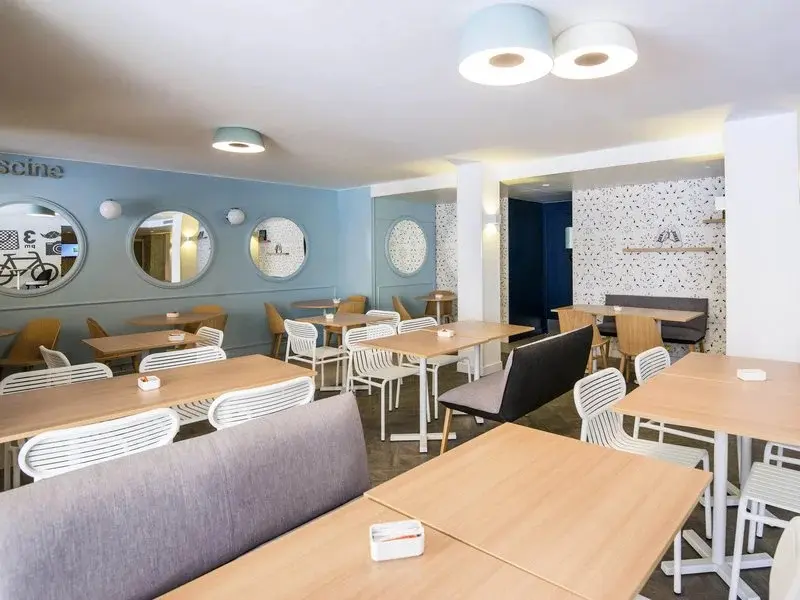 Une salle lumineuse avec des tables et des chaises pour les repas.