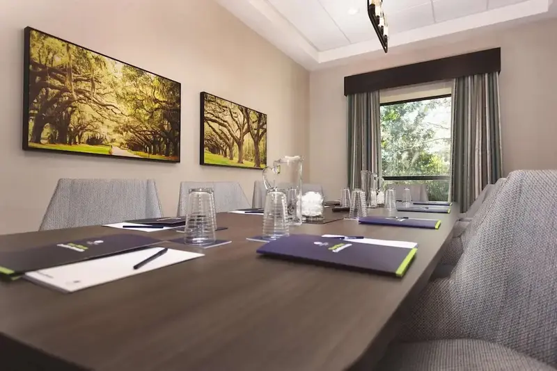 Une longue table de réunion est mise en place dans une salle lumineuse.