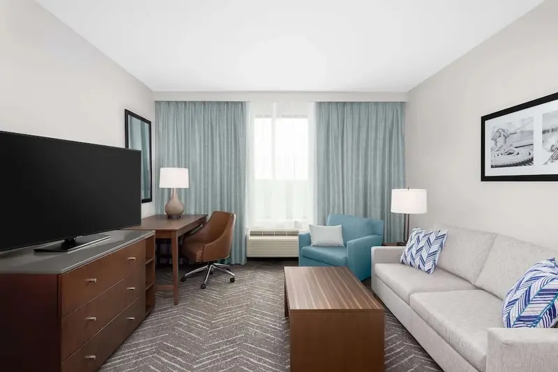 Un espace de vie intérieur avec un canapé, un fauteuil et un bureau.