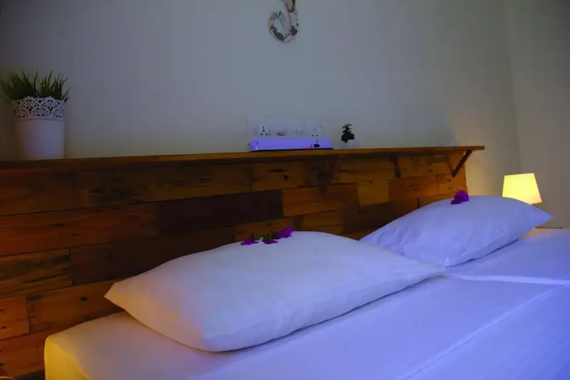 Un lit avec des oreillers blancs dans une chambre lumineuse.