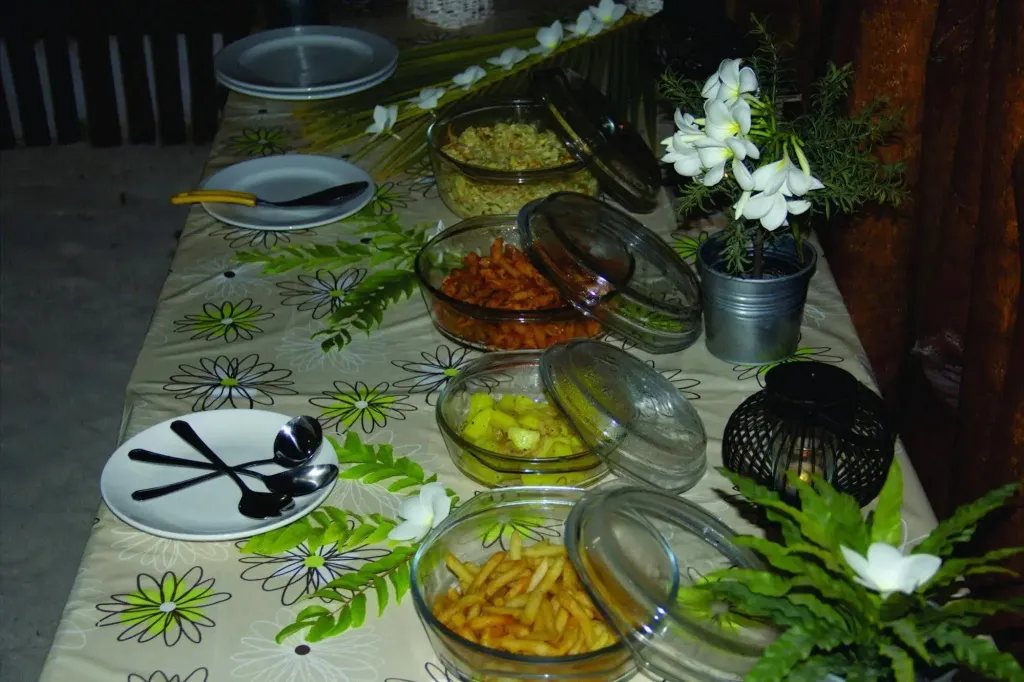 Présentation de plats variés sur un buffet décoré de fleurs.