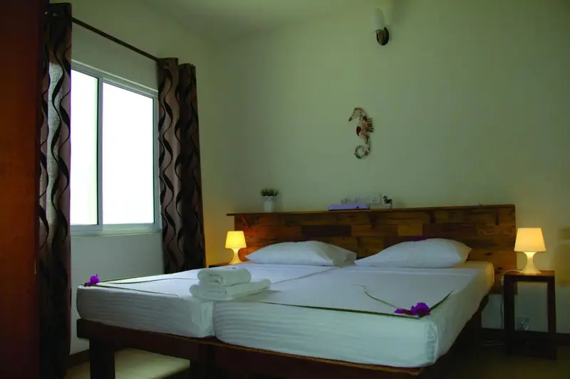 Une chambre lumineuse avec un lit double et des décorations murales.