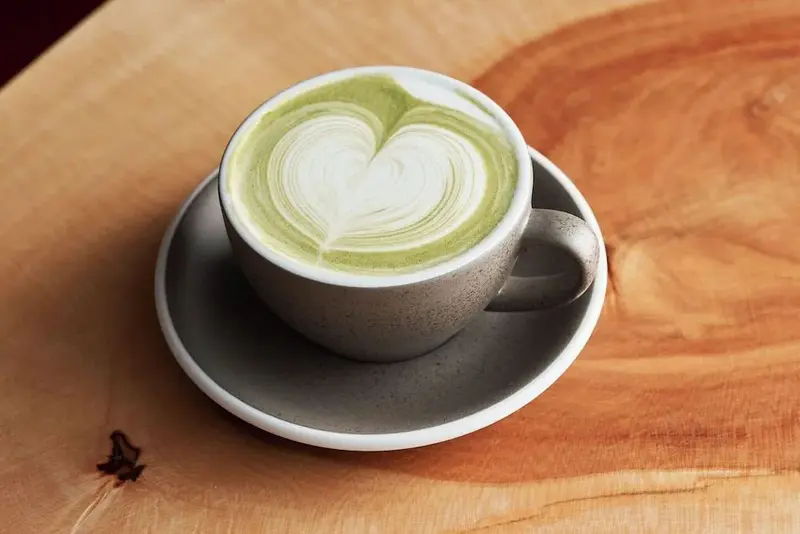 Une tasse de boisson chaude sur une surface en bois.