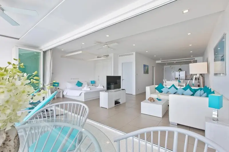 Espace de vie lumineux avec canapés et chambre à coucher.