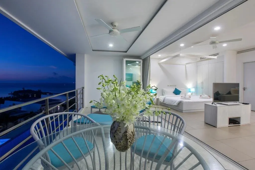 Une terrasse aménagée offre une vue sur la mer au crépuscule.