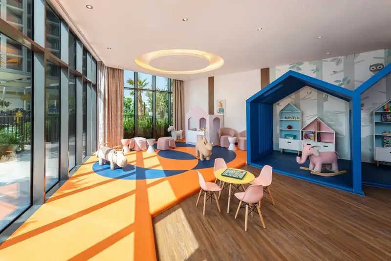 Espace de jeux coloré avec des jouets et une cabane en bois.