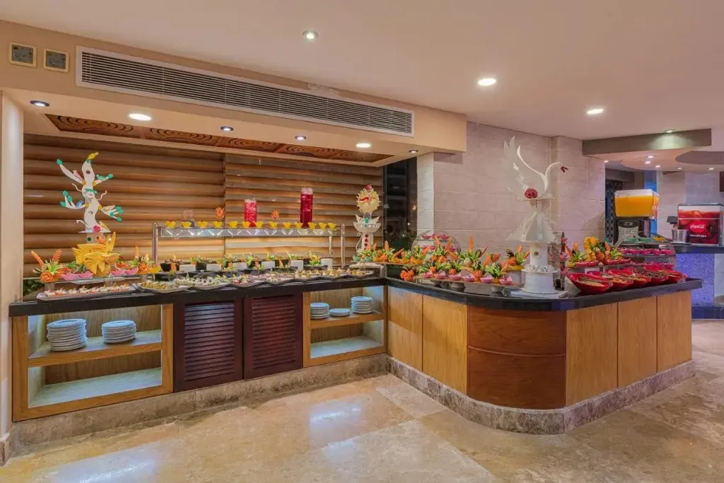 Un buffet coloré propose une variété de plats et de boissons dans une salle lumineuse.