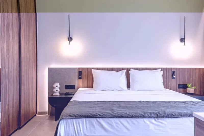 Une chambre lumineuse avec un grand lit recouvert de linge blanc.