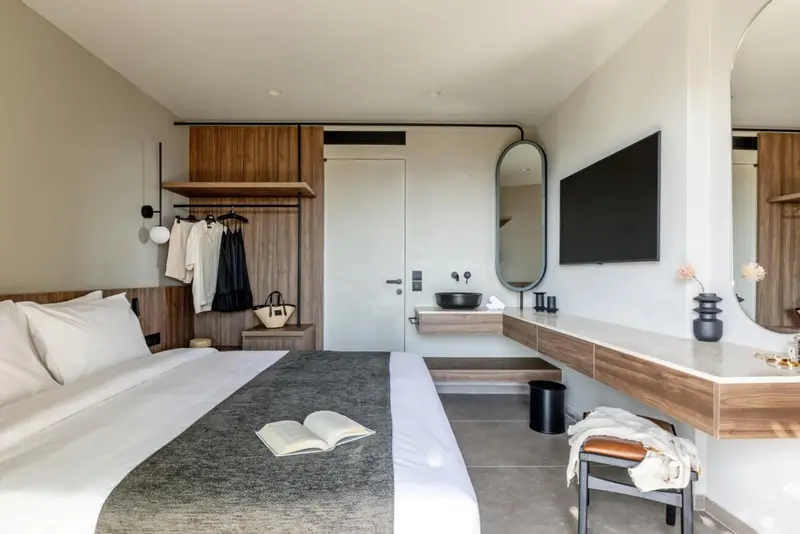 Une chambre lumineuse avec un grand lit et un espace coiffeuse.