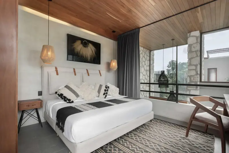 Une chambre lumineuse avec un grand lit et une décoration moderne.