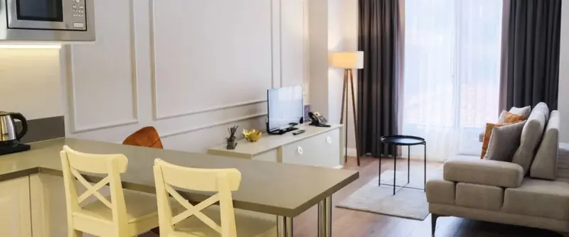 Un espace de vie lumineux avec un coin repas et un canapé près d'une fenêtre.