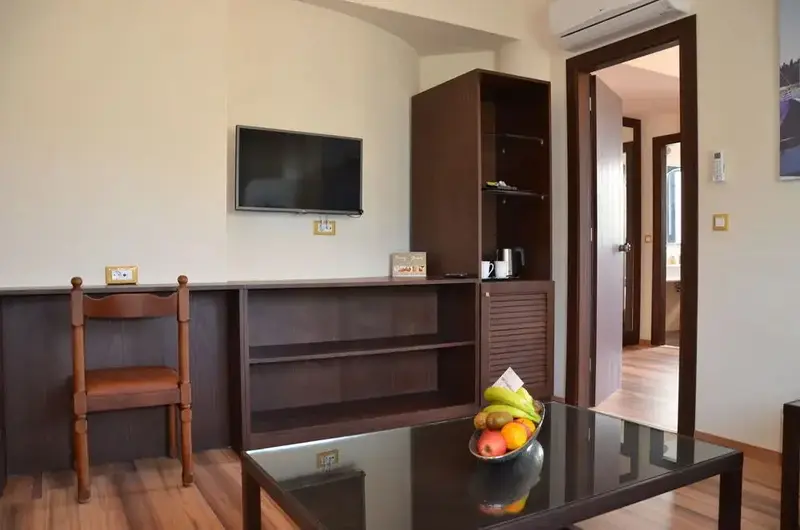 Une pièce lumineuse avec un bureau, un meuble de rangement et une table basse décorée de fruits.