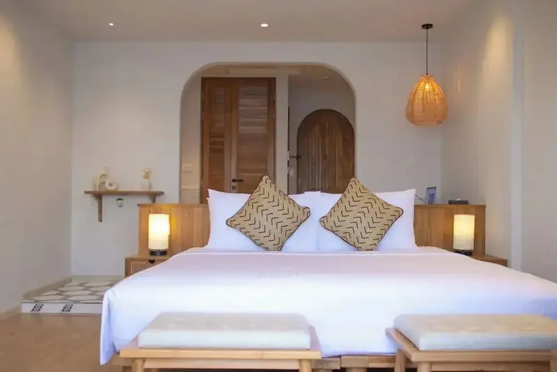 Une chambre lumineuse avec un grand lit et une décoration sobre.