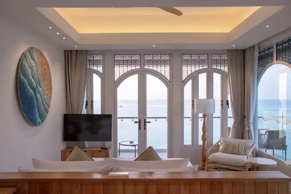 Espace de détente lumineux avec vue sur la mer depuis de grandes baies vitrées.
