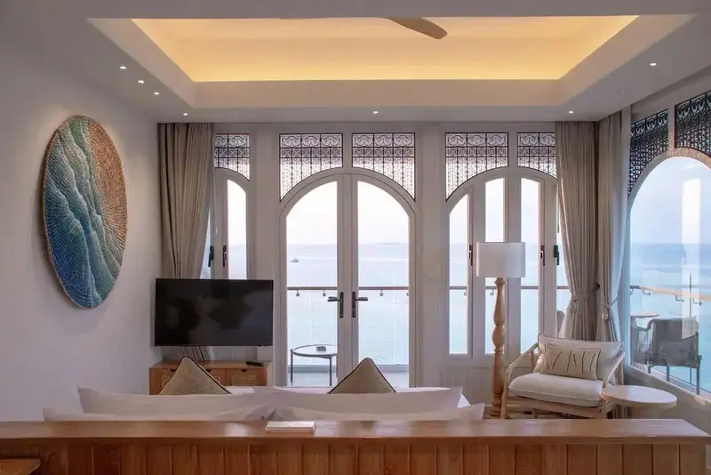 Espace de détente lumineux avec vue sur la mer depuis de grandes baies vitrées.