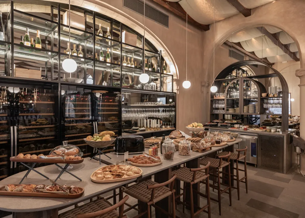 Un long comptoir de buffet propose une variété de pâtisseries et de fruits.