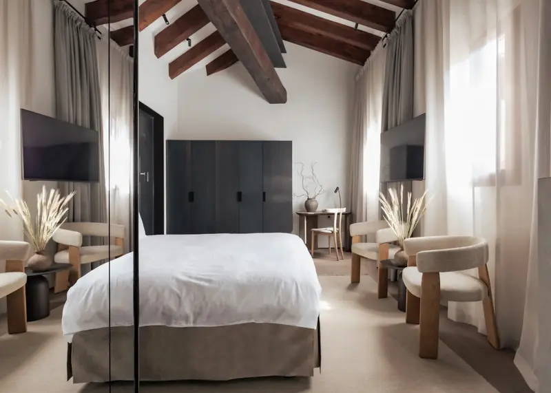 Une chambre lumineuse avec un grand lit et des meubles en bois.