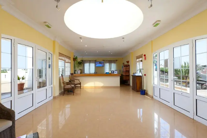 Hall d'accueil lumineux avec comptoir et mobilier d'attente.