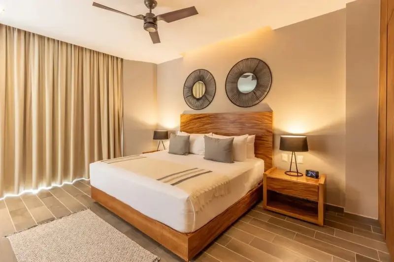 Une chambre lumineuse avec un grand lit et des éléments décoratifs en bois.