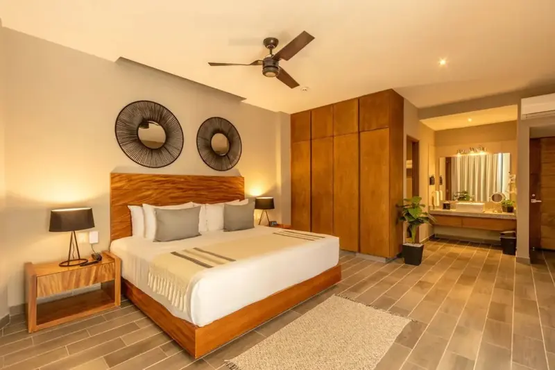 Une chambre lumineuse avec un grand lit et un décor en bois.