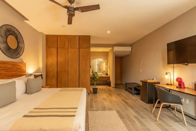 Une chambre lumineuse avec un grand lit et un espace bureau.