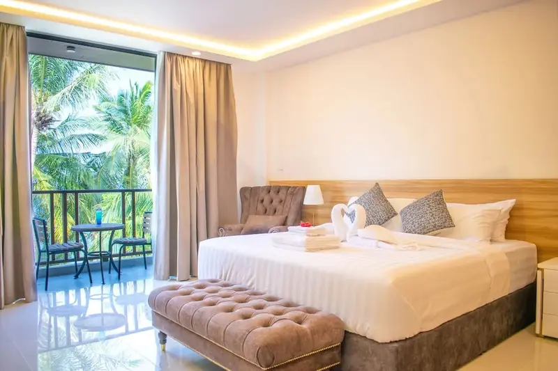 Une chambre lumineuse avec un lit king-size et un accès à un balcon.