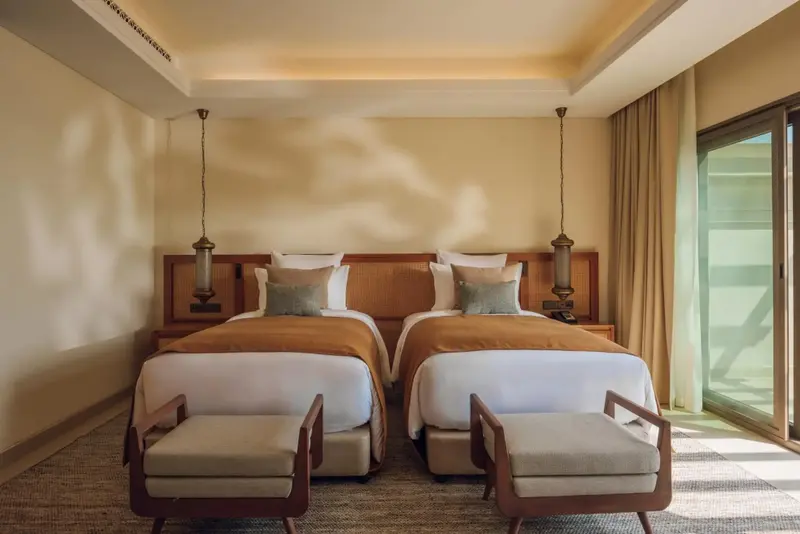 Deux lits simples dans une chambre lumineuse et décorée avec soin.
